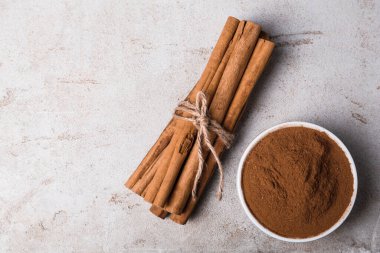 Aromatik tarçın çubukları ve pudra ışık masasında, düz yerde. Metin için boşluk