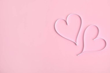 Pembe arka planda beyaz kurdelelerden yapılmış kalpler, metin için yeri olan düz bir yer. Sevgililer Günü kutlaması