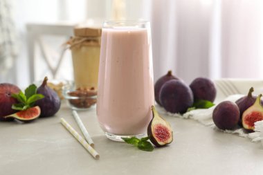 Işık masasının üzerinde cam içinde nefis incirli smoothie.
