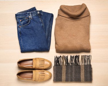 Düz kompozisyon, şık kıyafetler ve tahta arka planda ayakkabılar.