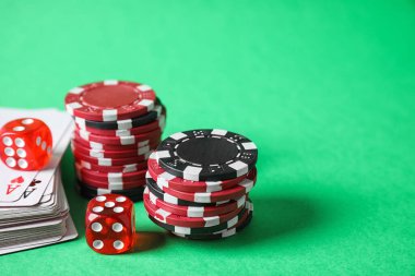 Yeşil arkaplanda poker çipleri, kartlar ve zarlar, metin için boşluk