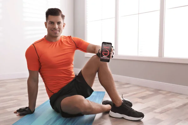 Homem Mostrando Smartphone Com Aplicativo Fitness Dentro Casa — Fotografia de Stock