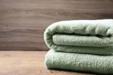 Ahşap masada katlanmış yumuşak havlular. Metin için boşluk