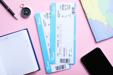 Pembe arka planda biletleri olan düz kompozisyon. Seyahat acentası kavramı