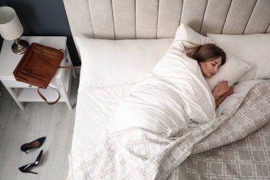 İşten sonra yatakta uyuyan yorgun bir kadın.