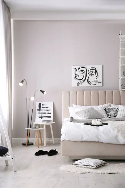 クッションと美しい写真と居心地の良いベッドルームのインテリア — ストック写真
