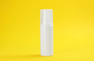 Sarı zemin üzerinde böcek kovucu sprey olan şişe.