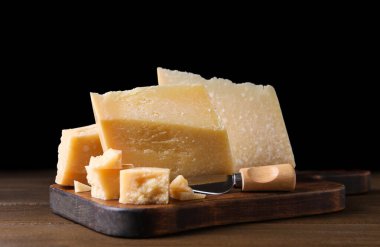 Ahşap masada bıçaklı nefis parmesan peyniri.