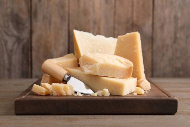 Ahşap masada bıçaklı nefis parmesan peyniri.