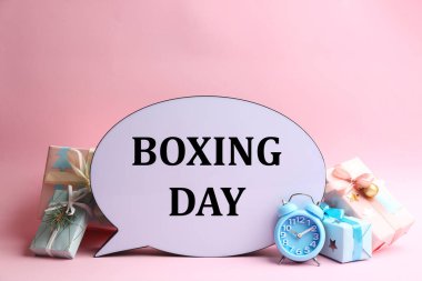 Boks Günü ve açık pembe arkaplan üzerine Noel süslemeleri içeren konuşma balonu