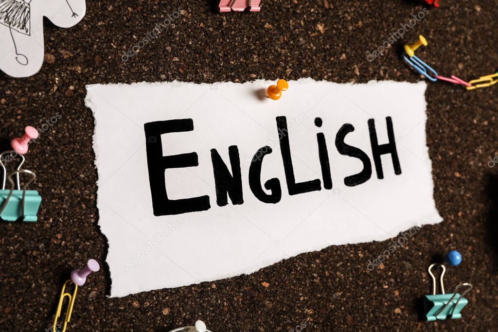 Hoja de papel con palabra Inglés y diferentes elementos en el tablero