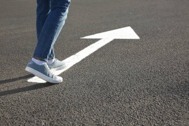 Kadın ok işaretli yolda ilerliyor, yakın plan.
