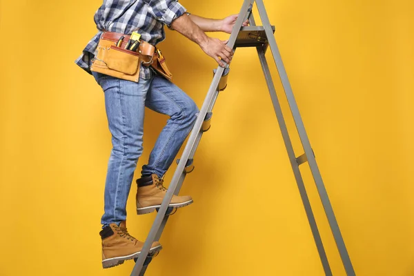 Constructor Profesional Subiendo Escalera Metal Sobre Fondo Amarillo Primer Plano — Foto de Stock