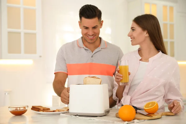 Pareja Feliz Preparando Desayuno Con Pan Tostado Mesa Cocina — Foto de Stock