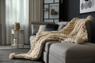 Oturma odasındaki kanepede beyaz örülü ekose kumaş. İç tasarım