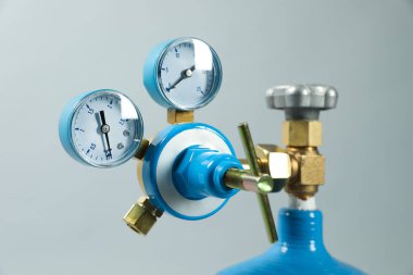 Açık gri arka planda tıbbi oksijen tankının basınç göstergesi, yakın plan