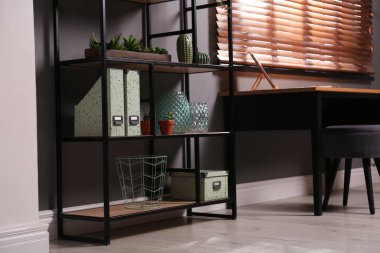 Odanın yanında farklı dekorları ve çiçekleri olan bir rafta. İç tasarım