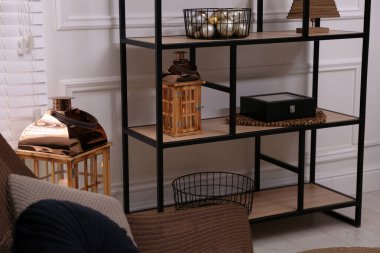 Beyaz duvarın yanında farklı dekorları olan şık bir raf ünitesi. İç tasarım