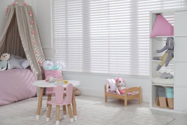 Oyuncak ve modern mobilyalarla dolu şirin bir çocuk odası.