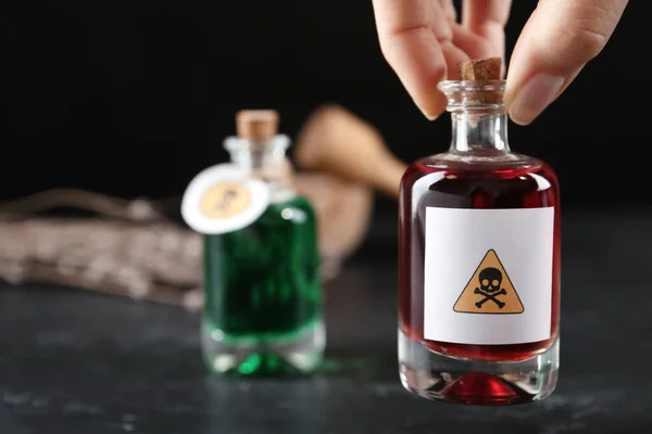 Γυναίκα Κρατώντας Γυάλινο Μπουκάλι Δηλητήριο Προειδοποιητική Πινακίδα Πάνω Από Τραπέζι — Φωτογραφία Αρχείου