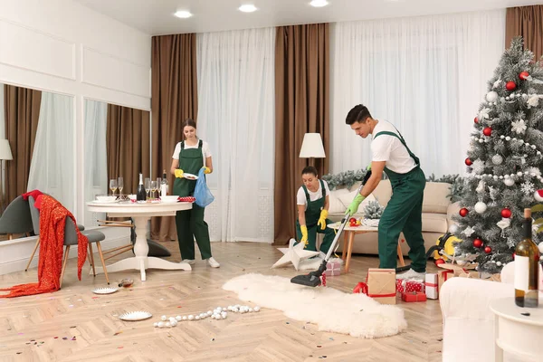 新年のパーティー後に乱雑な部屋で働く清掃サービスチーム — ストック写真