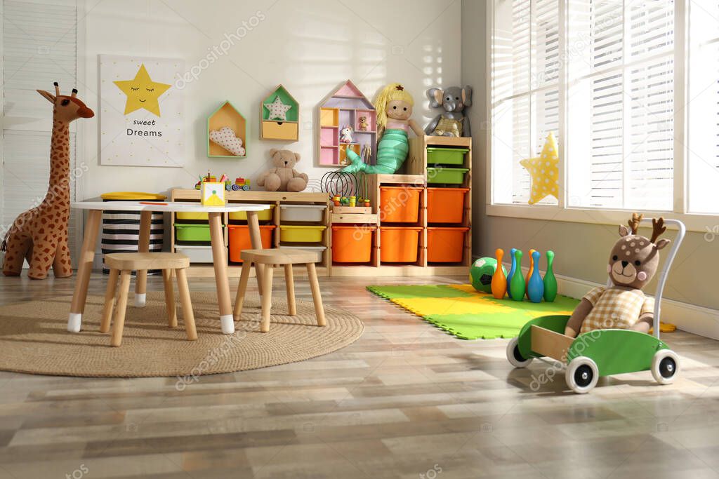 Stylish playroom interior with soft toys and modern furniture