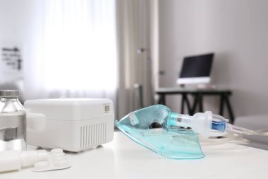 Beyaz masa üzerinde yüz maskesi ve ilaçları olan modern nebulizör. Solunum için ekipman