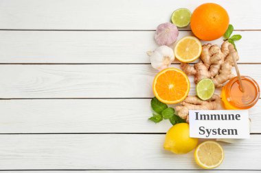 Üzerinde bağışıklık sistemi ifadesi olan kart ve beyaz ahşap masa üzerinde yeni ürünler, düz yatak. Metin için boşluk