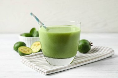 Beyaz ahşap masada cam içinde taze feijoa smoothie, yakın plan.