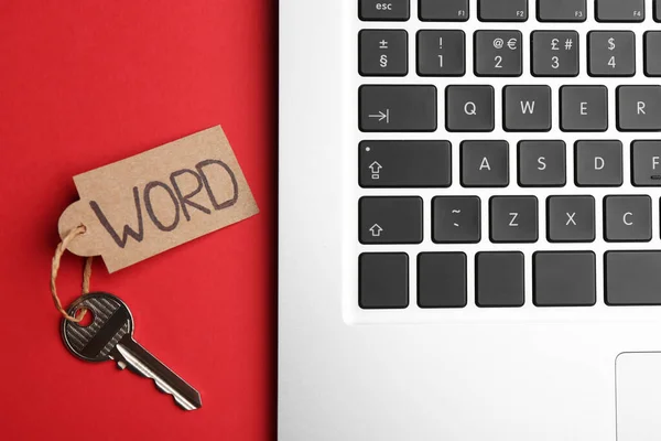 Schlüssel Mit Anhänger Und Laptop Auf Rotem Hintergrund Flach Gelegt — Stockfoto