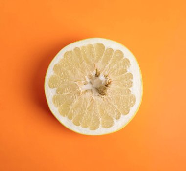 Turuncu arka planda taze kesilmiş pomelo meyvesi, üst manzara.