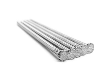 Beyaz arka planda bir sürü parlak metal çivi