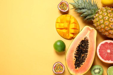 Taze olgun papaya ve sarı arka planda diğer meyveler. Düz yat. Metin için boşluk