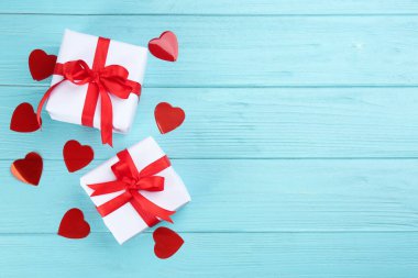 Turkuaz ahşap arka planda hediye kutuları ve kalpler, metin için yeri olan düz bir yer. Sevgililer Günü kutlaması