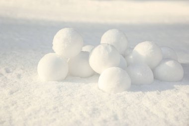 Pile of perfect round snowballs on snow outdoors clipart