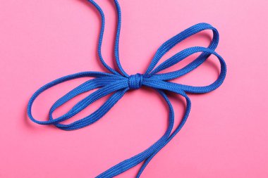 Pembe arka planda mavi ayakkabı bağcıkları, üst manzara