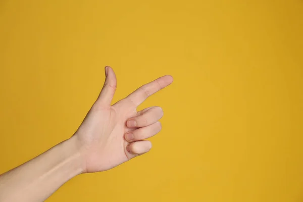 Kobieta Wskazująca Coś Żółtym Tle Zbliżenie Gest Palca — Zdjęcie stockowe