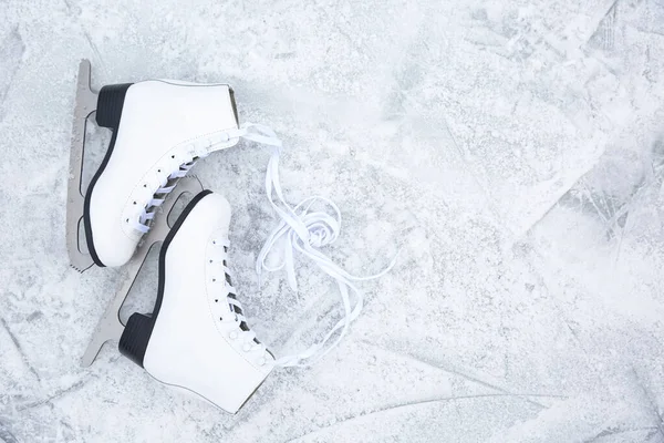 Pair of figure skates on ice, flat lay with space for text. Winter outdoors activities