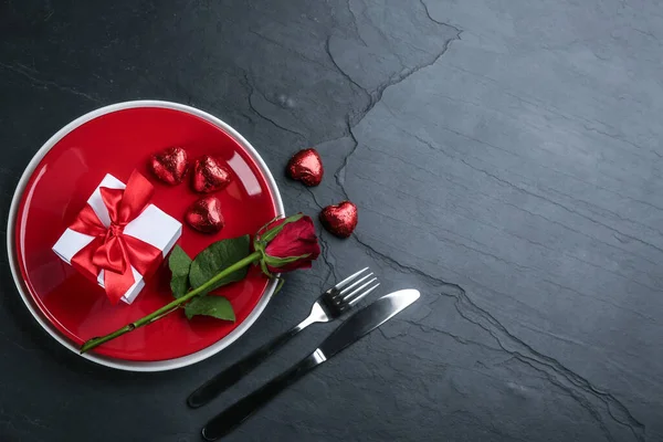 Beautiful table setting on black background, flat lay with space for text. Valentine\'s Day dinner