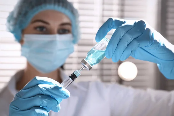 Kvinna Fyllningsspruta Med Vaccin Från Injektionsflaska Mot Suddig Bakgrund Fokus — Stockfoto