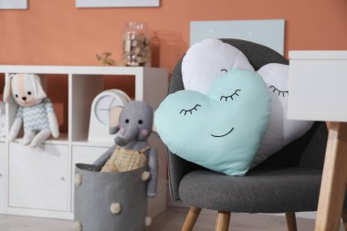 Oyun odasında sevimli yastıklı sandalye, mesaj için yer. İç tasarım