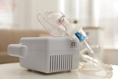 Beyaz masa içinde yüz maskesi olan modern nebulizör. Solunum cihazları
