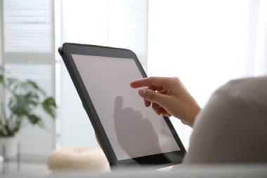Evde modern tablet kullanan bir kadın, yakın çekim. Tasarım için boşluk