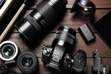 Kahverengi ahşap arka planda kamera ve video yapım ekipmanlarıyla düz konum