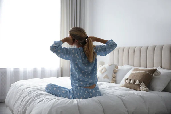若い女性のベッドの上で自宅で バックビューストレッチ 朝のフィットネス — ストック写真