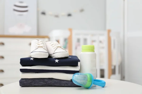 Stapel Babykleertjes Schoenen Accessoires Witte Tafel Binnen — Stockfoto