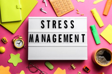 Pembe arkaplandaki Stres Yönetimi ifadesiyle ışık kutusunun düz konumu