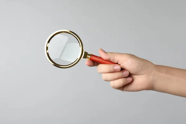 Kvinna Som Håller Förstoringsglas Grå Bakgrund Närbild Hitta Nyckelord Koncept — Stockfoto