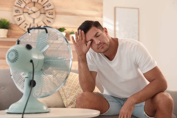 Uomo Godendo Flusso Aria Dal Ventilatore Sul Divano Soggiorno Calore — Foto Stock