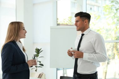 Ofis çalışanları tatilde işyerinde konuşuyor.